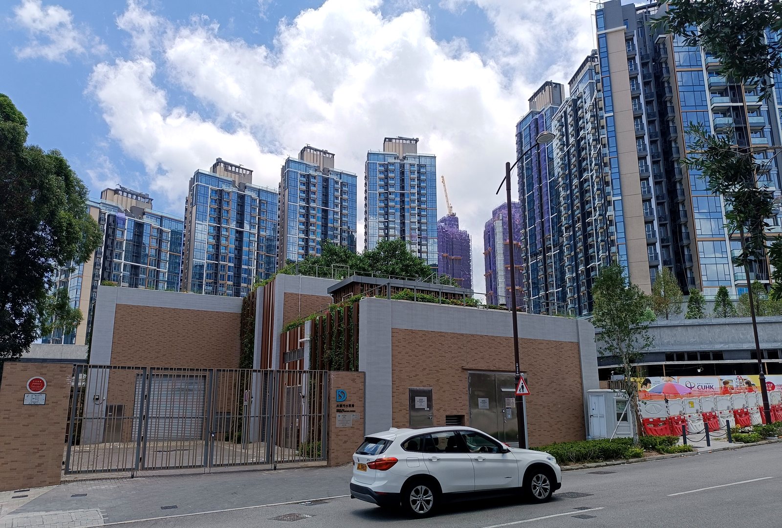 Sierra Sea 項目入口實景，可見住宅大樓群及入口閘門